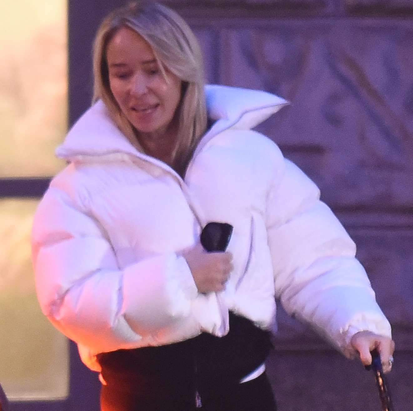 Joanna Przetakiewicz w białej kurtce wychodzi z restauracji