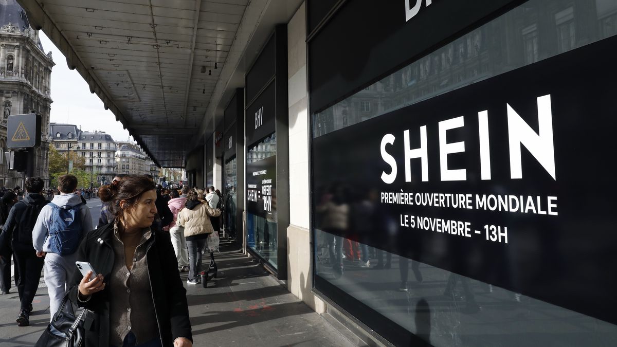 PARIS, FRANCE - NOVEMBER 5: Pedestrians walk past a Shein banner advertisement for its inauguration at the BHV Marais, in front of the BHV in Paris, France on November 5, 2025.The partnership between the brand and the Paris Department store has provoked criticisms by politicians, unions and top fashion brands. (Photo by Antoine Gyori - Corbis/Corbis via Getty Images)