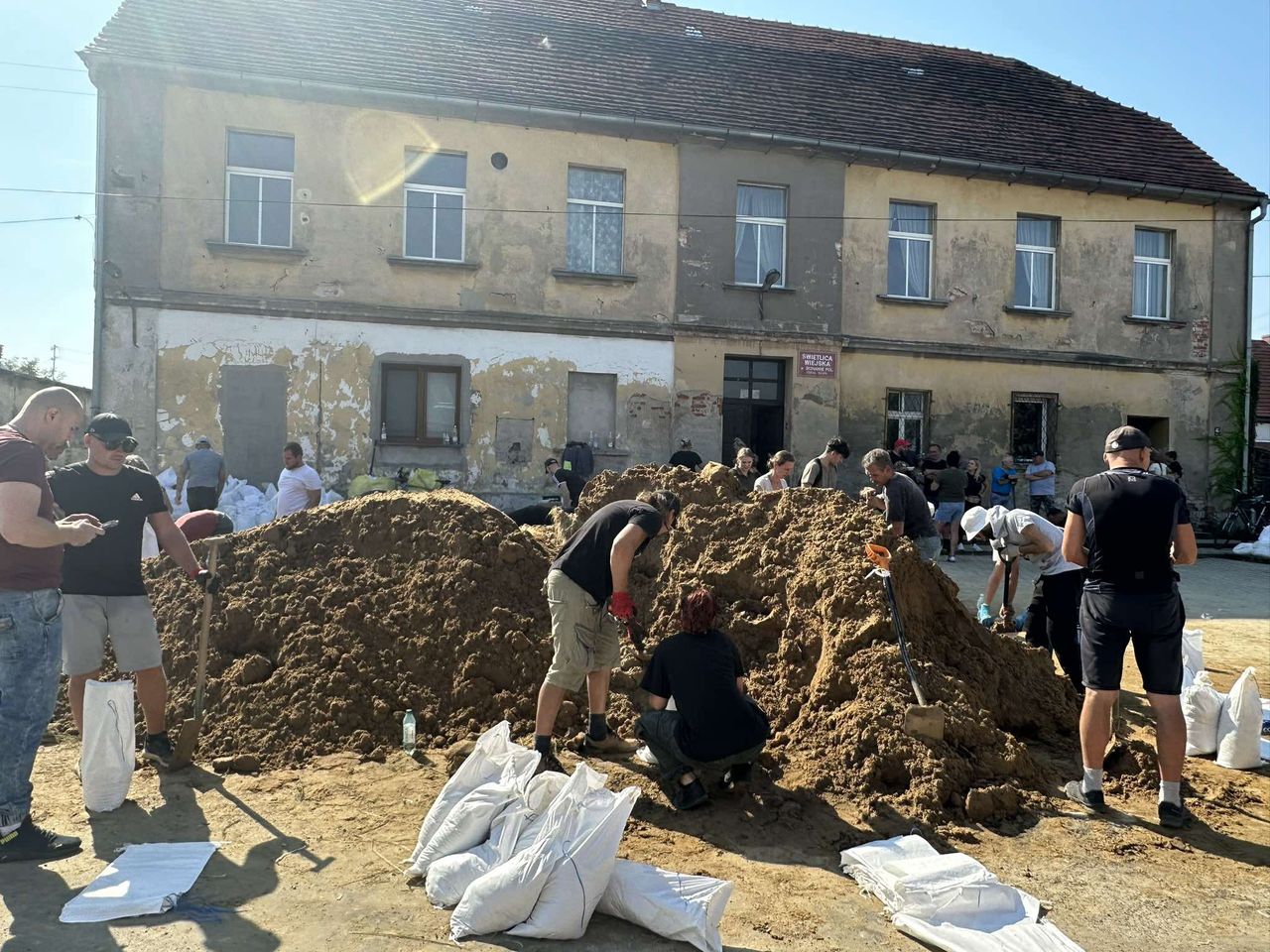 Mieszkańcy Ścinawy napełniają worki z piaskiem