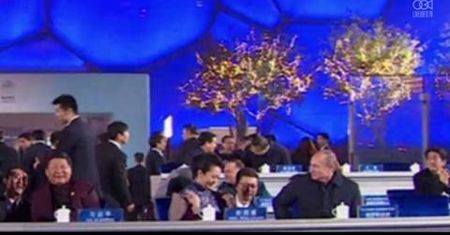 Putin podaje pled żonie prezydenta Chin Xi podczas pokazu sztucznych ogni na stadionie Bird's Nest