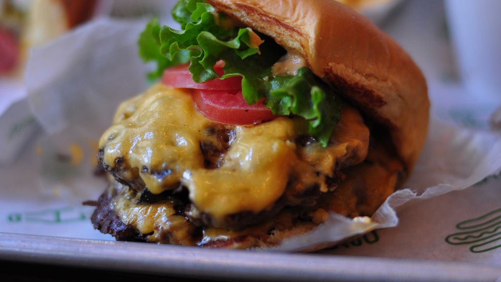 Powiększony cheeseburger z przyprawami i warzywami