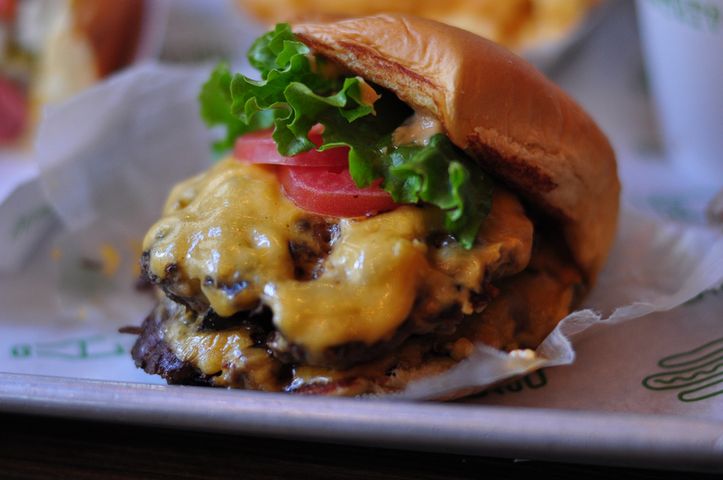 Powiększony cheeseburger z przyprawami i warzywami