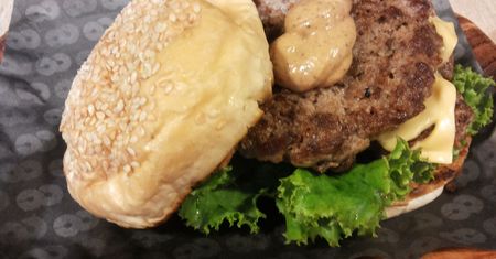 Powiększony podwójny cheeseburger z przyprawami i warzywami