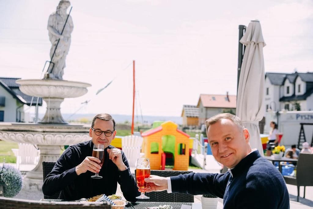 Duda i Morawiecki popijają piwo z sokiem nad morzem