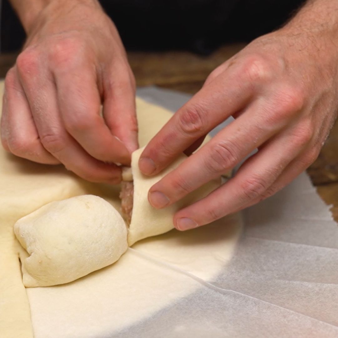 It's time to hide the meatballs in the dough.