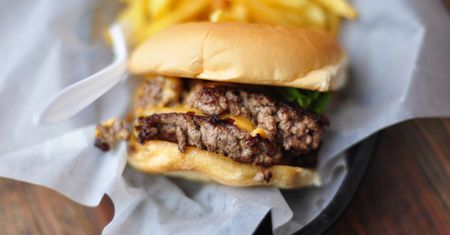 Powiększony podwójny hamburger z przyprawami i warzywami