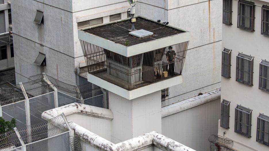 47 Pro-Democracy Activists Appear In Court For Hong Kong Subversion Case
A member of the Correctional Services Department (CSD) stands guard in a watch tower at the Lai Chi Kok Reception Center in Hong Kong, China, on Thursday, July 8, 2021. Pro-democracy activists are being prosecuted over their roles in helping organize a primary that drew more than 600,000 voters in July last year to choose candidates for Legislative Council elections that were later postponed. Photographer: Chan Long Hei/Bloomberg via Getty Images
Bloomberg
east asian, judiciary, justice, nsl, chinese, national security law, courts, correctional facility; jail; penitentiary, hkprotest2021, china