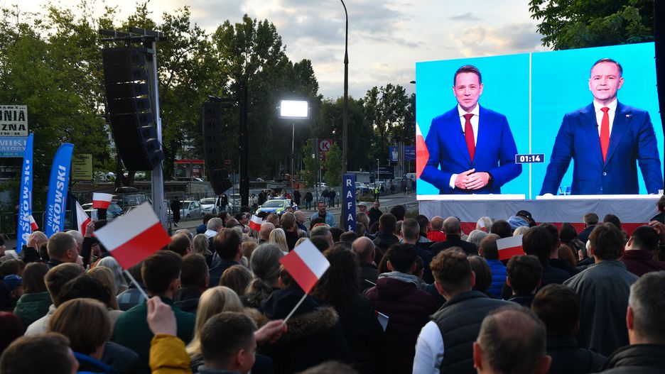 Warszawa, 23.05.2025. Wybory Prezydenta RP 2025 - kampania przed II turą. Ludzie oglądają na telebimach debatę kandydatów przed II turą wyborow prezydenta RP, transmitowaną przez trzy ogólnopolskie stacje ? TVP, TVN i Polsat, przed gmachem TVP w Warszawie, 23 bm. (ad) PAP/Piotr Nowak