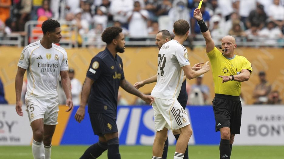 Sędzia Szymon Marciniak pokazuje żółtą kartkę ofensywnemu pomocnikowi Jude Bellinghamowi (z lewej) w 87. minucie meczu Real Madryt z Juventusem w 1/8 finału KMŚ