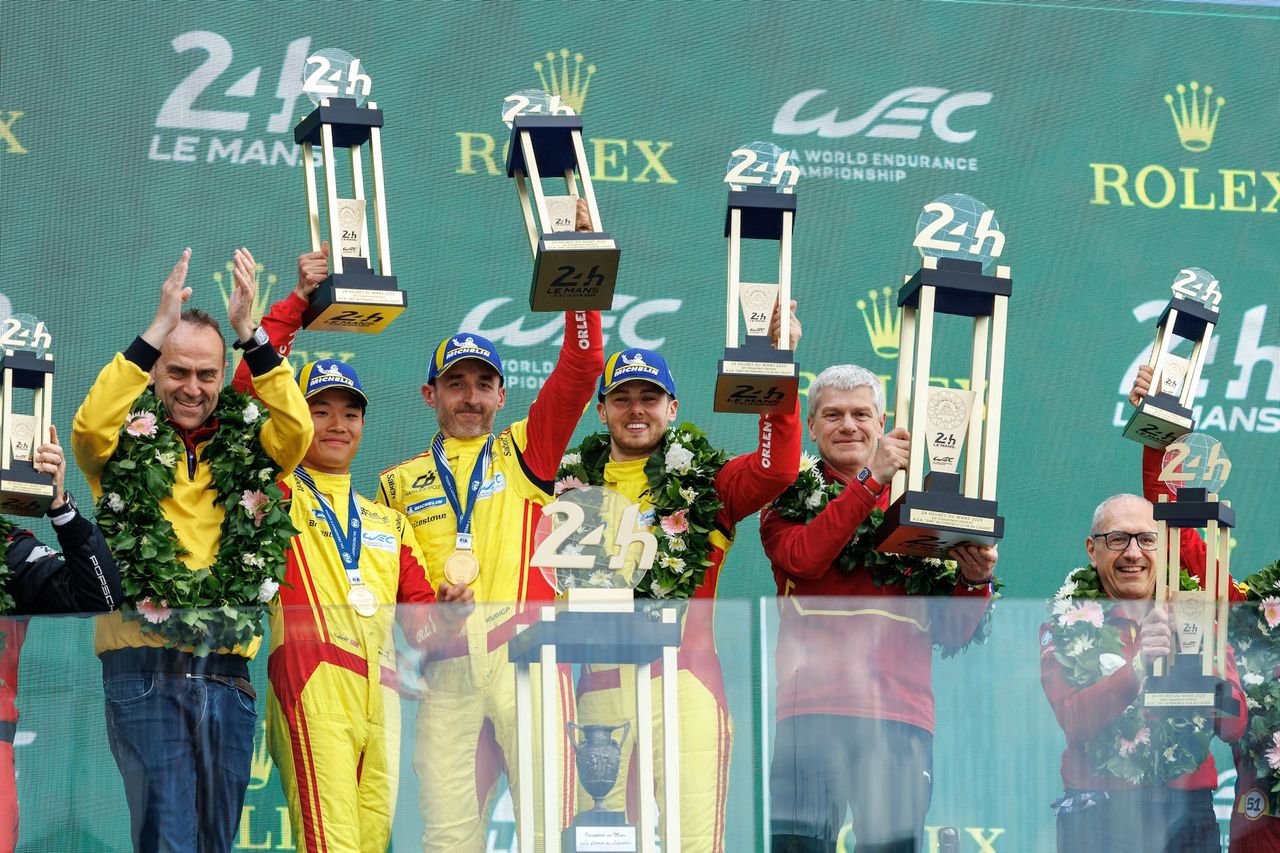 Robert Kubica wraz z zespołem i trofeami za zwycięstwo
