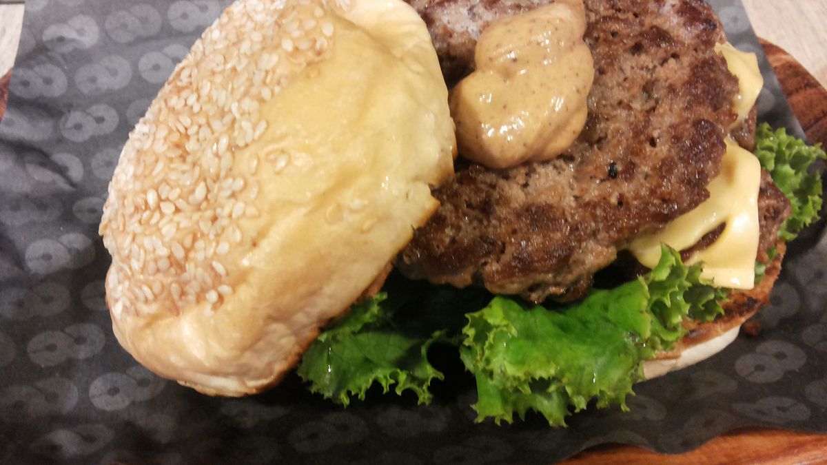 Powiększony podwójny cheeseburger z przyprawami i warzywami