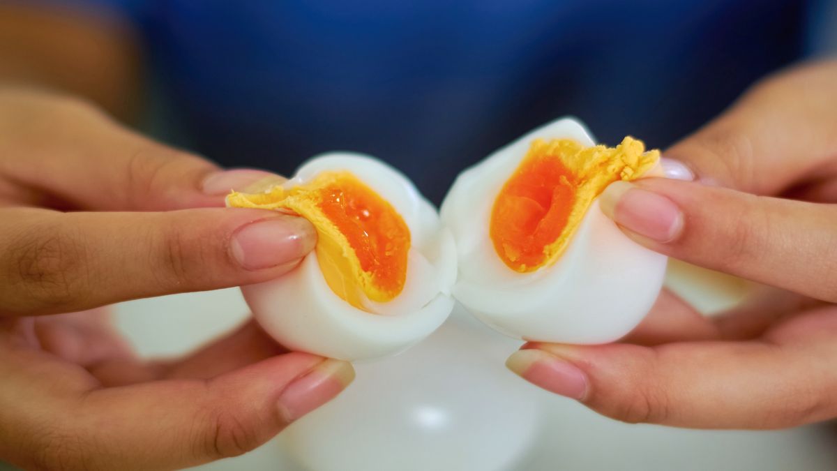 Hands Cracking Open a Soft-Boiled Egg Revealing a Perfectly Juicy Yolk
A close-up view of two hands gently splitting a soft-boiled egg, revealing its golden, runny yolk. The image showcases the delicate texture of the egg, with the creamy yolk oozing out against the smooth, cooked egg white.
Krit of Studio OMG