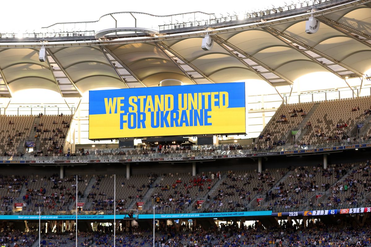 PERTH, AUSTRALIA - MARCH 20: We Stand For Ukraine signage is displayed on the stadium screens at the half time break during the round one AFL match between the West Coast Eagles and the Gold Coast Suns at Optus Stadium on March 20, 2022 in Perth, Australia. (Photo by Paul Kane/Getty Images)