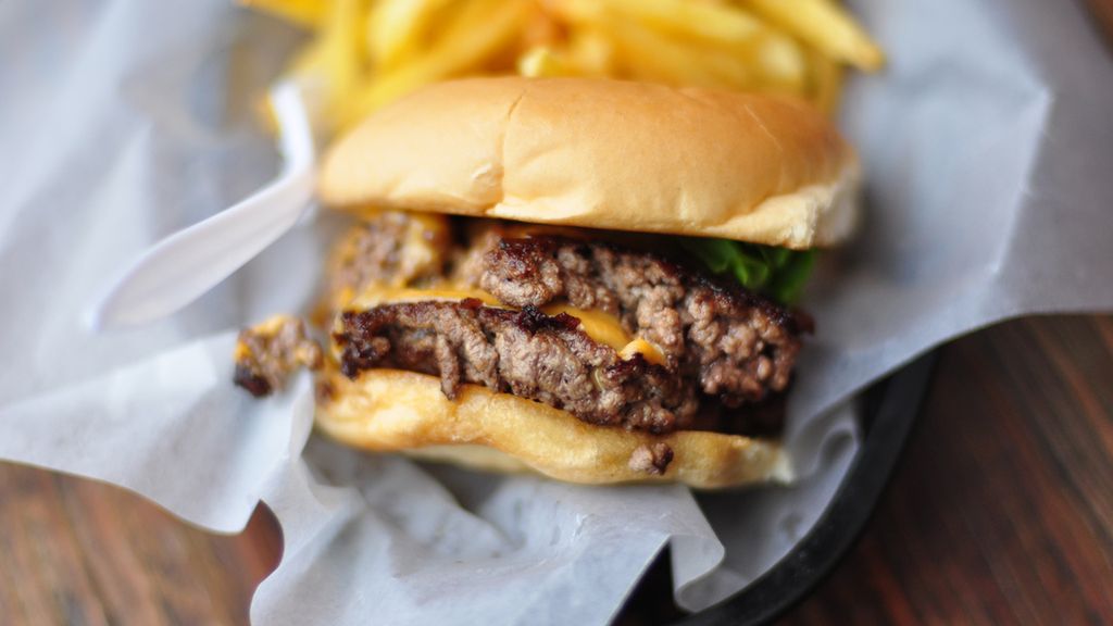 Powiększony podwójny hamburger z przyprawami i warzywami