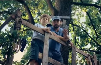 Tata i syn na szczycie magicznego drzewa w kampanii otoDom.pl