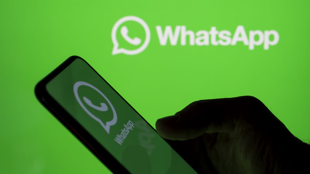 In Créteil, France, on September 29, 2025, the WhatsApp logo appears on a smartphone held in one hand with the WhatsApp logo in the background. Meta, the parent company of WhatsApp and Meta AI, makes the Artificial Intelligence assistant mandatory in its instant messaging app. (Photo Illustration by Samuel Boivin/NurPhoto via Getty Images)