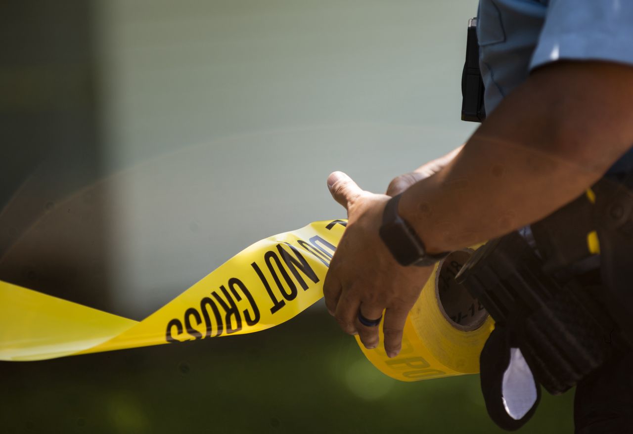 MINNEAPOLIS, MN - JUNE 16: A Minneapolis Police officers unrolls caution tape at a crime scene on June 16, 2020 in Minneapolis, Minnesota. The Minneapolis Police Department has been under increased scrutiny by residents and elected officials after the death of George Floyd in police custody on May 25. (Photo by Stephen Maturen/Getty Images)