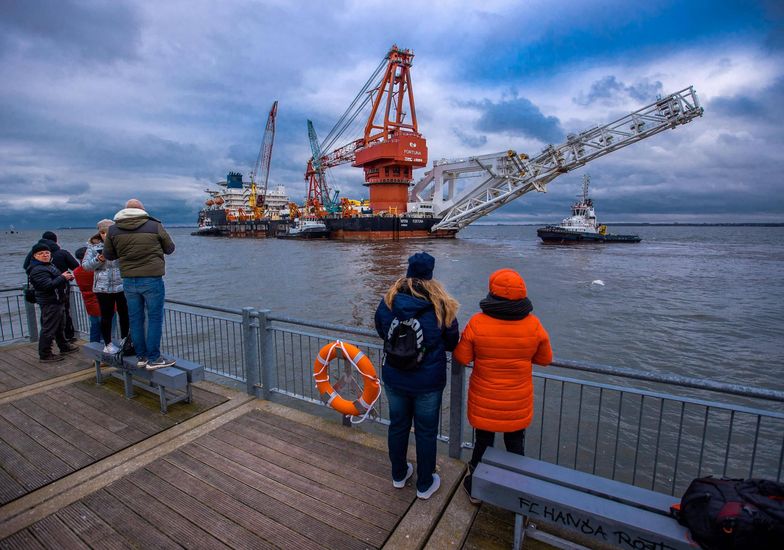 Russian laying ship "Fortuna"14 January 2021, Mecklenburg-Western Pomerania, Wismar: Passers-by take pictures of the Russian pipe-laying vessel "Fortuna" on the pier, which is being towed out of the harbour onto the Baltic Sea by tugboats. The special ship is being used for construction work on the German-Russian Nord Stream 2 gas pipeline in the Baltic Sea. Media reported, citing authorities in Denmark, that pipe-laying work should begin in Danish waters in mid-January 2021, with the Russian pipe-laying vessel "Fortuna" to be used. Photo: Jens B�ttner/dpa-Zentralbild/ZB 
Dostawca: PAP/DPA.Jens B�ttnerShipping, Web, Building, Seasons, Water, Winter, Nord Stream, Pipe Layers, Crane, Baltic Sea, Communities, Industrial port, Special ship, red, Shipping company, Gas line, Laying vessel, Russia, Sky, Clouds, Lifebelt, Exterior shot, Feature, Group