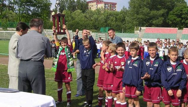Arkadiusz Milik odbiera puchar za zwycięstwo w dziecięcym turnieju. W tle Sławomir Mogilan (z lewej) oraz brat Arkadiusza, Łukasz (z prawej). fot. KS ROZWÓJ KATOWICE, rocznik 1994.