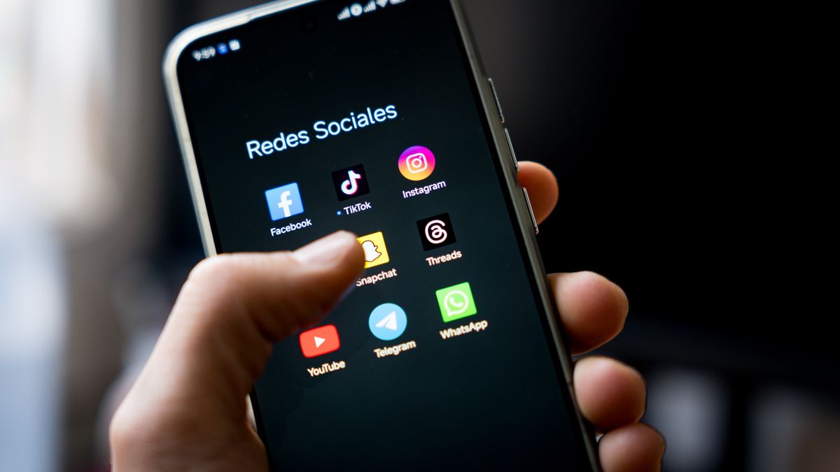 SPAIN - 2026/02/04: In this photo illustration, a woman is seen using social media apps Facebook, TikTok, Instagram, X, Snapchat, Threads, YouTube, Telegram, and WhatsApp on a smartphone at home. Spanish Prime Minister Pedro Sánchez, announced on the 3 February a law to ban access to social media for children under 16, as Spain joins five other European countries in the "Coalition of the Digital Willing" to advance coordinated and effective regulation of social media platforms and strengthen age-verification systems across Europe. (Photo Illustration by Davide Bonaldo/SOPA Images/LightRocket via Getty Images)