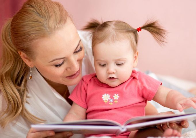 Mama czytająca dziecku książeczkę.