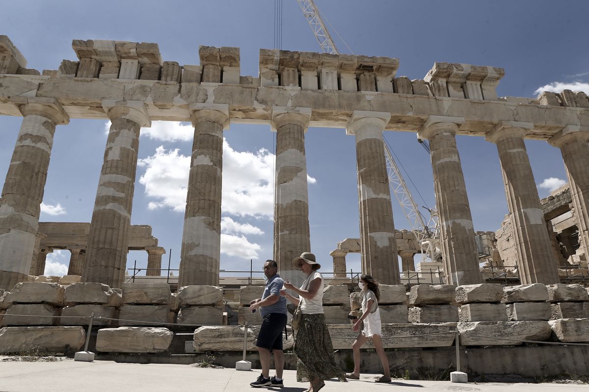 Tourist walk in front the ancient temple of Parthenon at the Acropolis hill, on June 2, 2021 (Photo by Panayotis Tzamaros/NurPhoto via Getty Images)