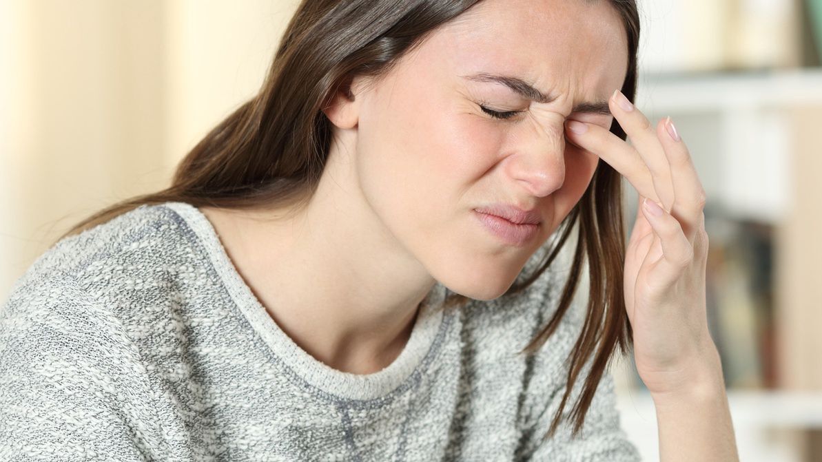 Woman scratching itchy eye at homeWoman scratching itchy eye at homeAntonioGuillem