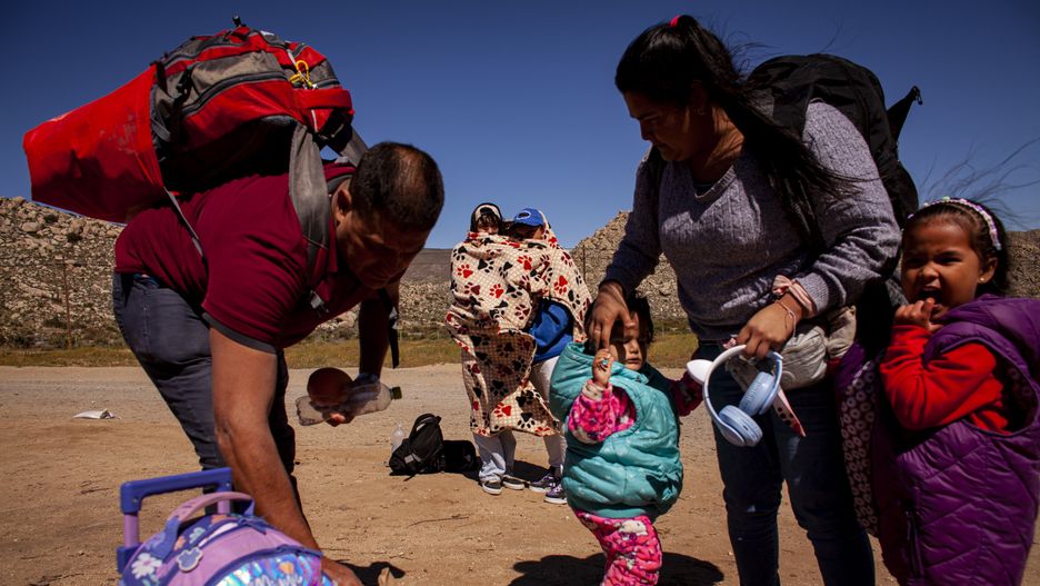 Jacumba Hot Springs, California, USA  APRIL 15: Jose, his wife and two kids pack up their belongings. The parents and two kids from Colombia just illegally crossed the US-Mexico border early that morning on April 15, 2024. 21-year-old Camilo and 22-year-old Brandon share a blanket in cold wind, standing behind them, they are also from Colombia. (Photo by Li Qiang for The Washington Post via Getty Images)