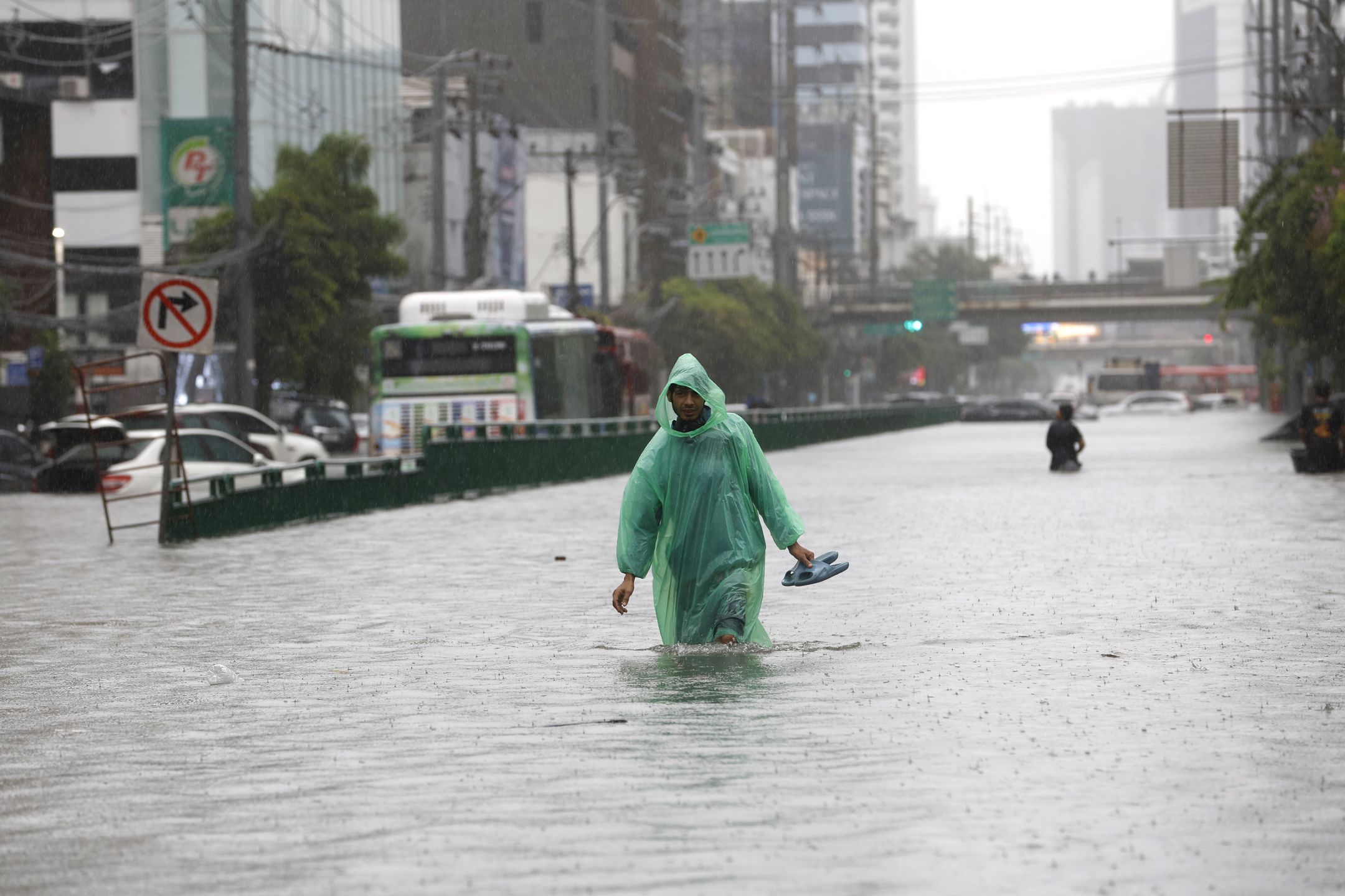 A man carries his shoe wades through floodwater during a downpour on a flooded major street, Phetchaburi Road in Bangkok, Thailand, 26 September 2026. All 50 districts in Bangkok have been declared flood disaster zones following the non-stop heavy downpour caused by a strong low-pressure system combined with seasonal monsoon patterns. EPA/RUNGROJ YONGRIT Dostawca: PAP/EPA.