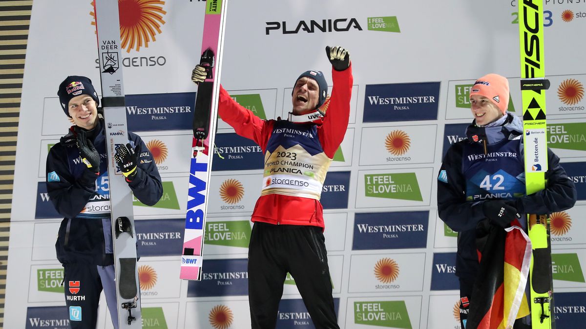 Planica, Słowenia, 25.02.2023. Mistrzostwa świata w narciarstwie klasycznym Planica 2023. Skoczkowie na podium. Piotr Żyła (C) został 25 bm. w Planicy mistrzem świata w skokach narciarskich na normalnym obiekcie. Polak wyprzedził Niemców Andreasa Wellingera (L) i Karla Geigera (P). (gj) PAP/Grzegorz Momot