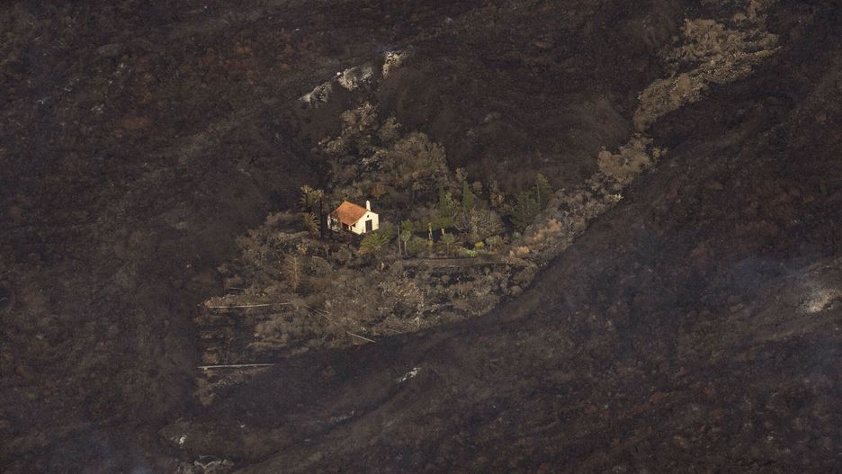 TemporaryLava from a volcano eruption surrounds a house on the island of La Palma in the Canaries, Spain, Thursday, Sept. 23, 2021. A volcano on a small Spanish island in the Atlantic Ocean erupted on Sunday, forcing the evacuation of thousands of people. Experts say the volcanic eruption and its aftermath on a Spanish island could last for up to 84 days. (AP Photo/Emilio Morenatti, Pool)AP Pool