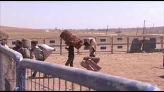 Uchodźcy z Syrii przekraczają prowizoryczny punkt kontrolny na granicy z Turcją