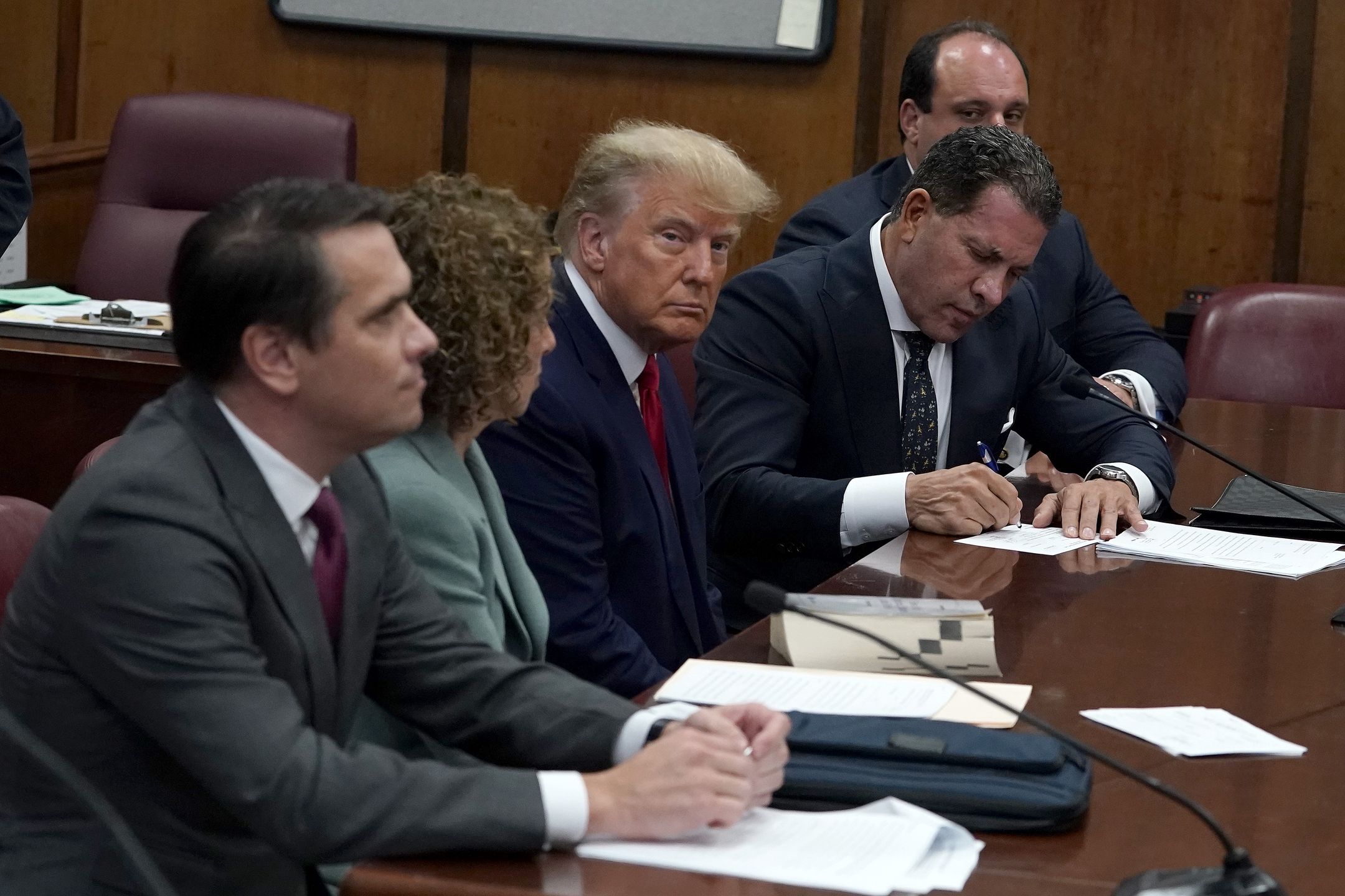 NEW YORK, NY - APRIL 04:  Former U.S. President Donald Trump sits with his attorneys inside the courtroom during his arraignment at the Manhattan Criminal Court April 4, 2023 in New York City. Trump pleaded not guilty to 34 felony counts stemming from hush money payments made to adult film star Stormy Daniels before the 2016 presidential election. With his indictment, Trump will become the first former U.S. president in history to be charged with a criminal offense. (Photo by Timothy A. Clary-Pool/Getty Images)