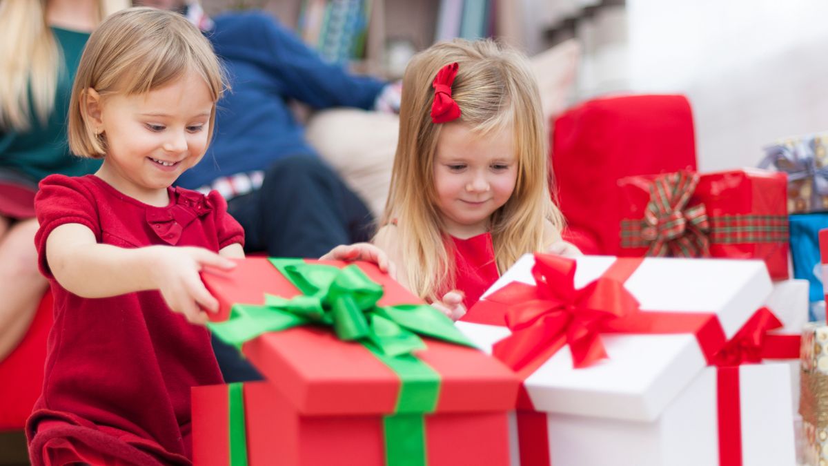 Małe dziewczynki otwierają prezenty.