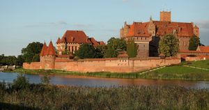 Malbork Castle stands at sunset over the Nogat River in Malbork, Poland, on September 1, 2025. Built by the Teutonic Order in several stages from 1280 to the mid-15th century, the castle is recognized as a historical monument and is included on the UNESCO World Heritage List. (Photo by Klaudia Radecka/NurPhoto via Getty Images)