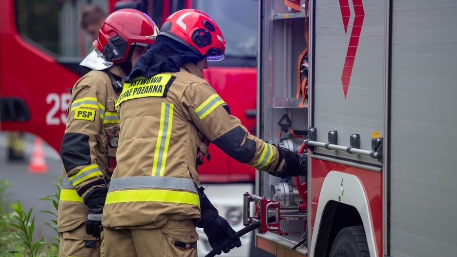 Strażacy podłączający wąż. Straż pożarna przy wypadku. Pożar