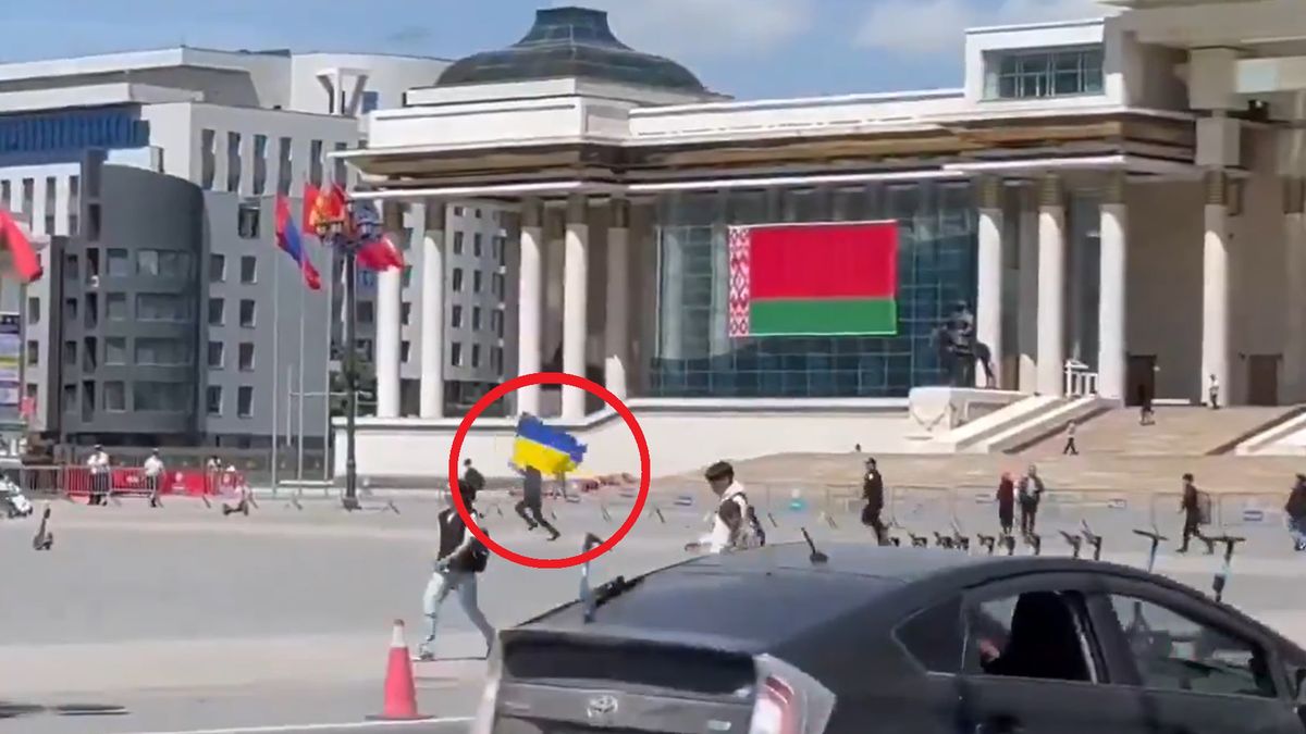 Mężczyzna biegnący z ukraińską flagą