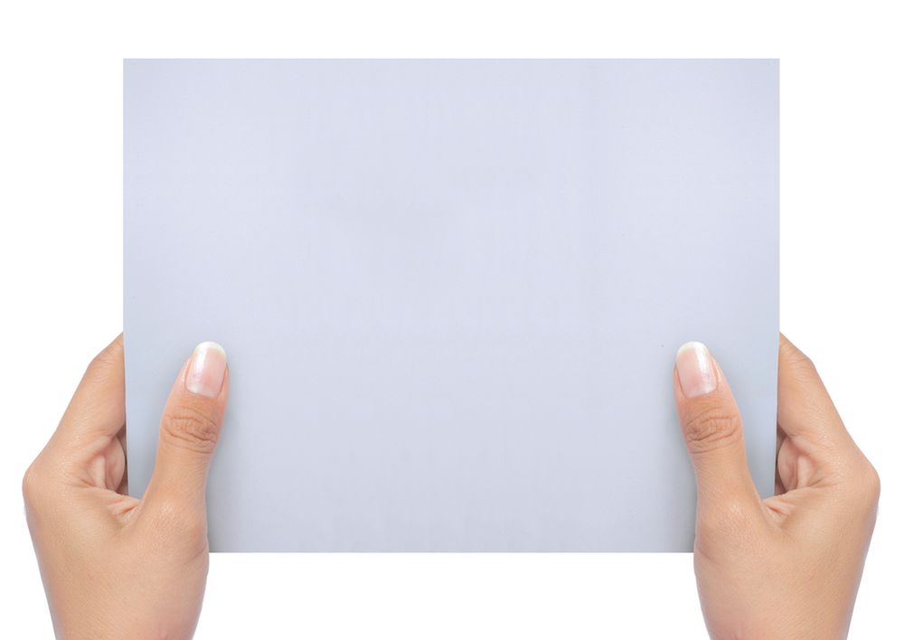 Hand holding a blank white paper