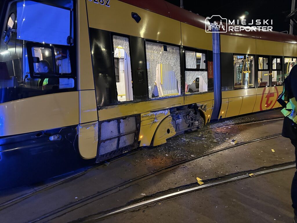 Tramwaj z uszkodzoną boczną szybą stoi na torach, a wewnątrz widać kierowcę w zielonej kamizelce.