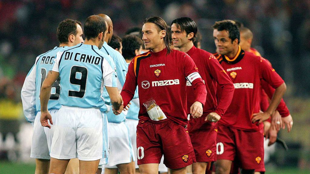 piłkarze Lazio i Romy, na przodzie uścisk rąk Paolo Di Canio i Francesco Tottiego