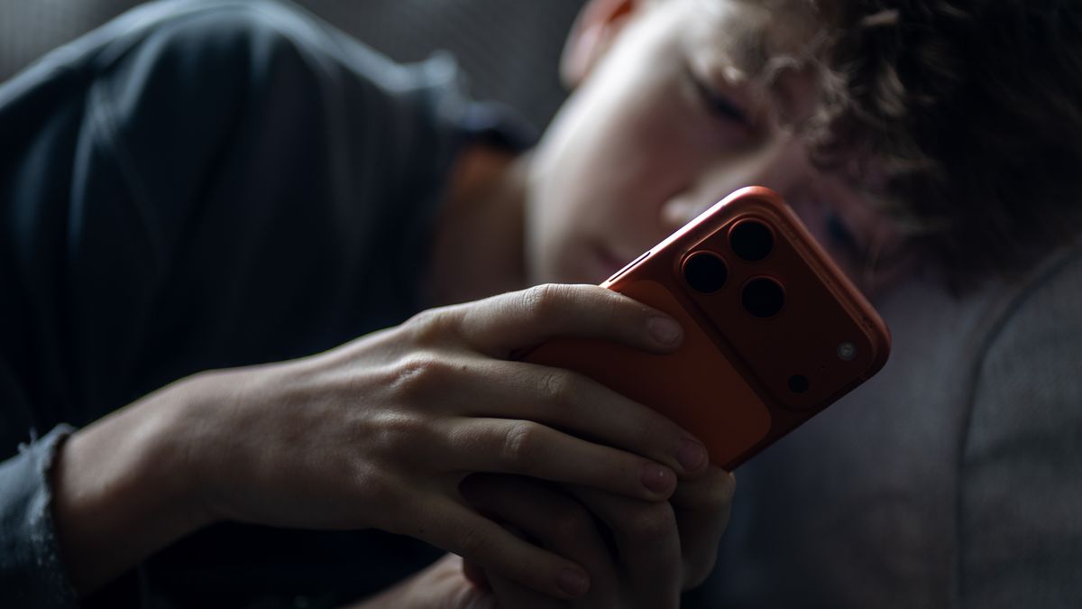 BATH, UNITED KINGDOM - MARCH 29: In this photo illustration a 14-year-old boy looks at an iPhone screen displaying various social media and messaging apps on March 29, 2026 in Bath, England. In the UK, a ban on social media for under-16s has been backed by the House of Lords following the Australian law which aims to stop children under 16 from having social media accounts and social media platforms, including TikTok, Facebook, Snapchat, Reddit, X, formerly Twitter, and Instagram potentially being be fined for preventing children younger than 16 from having social media accounts. (Photo by Anna Barclay/Getty Images)