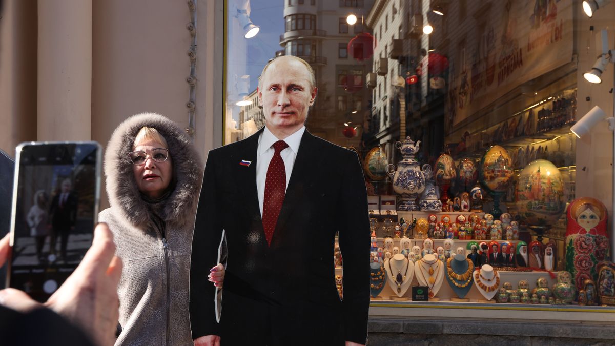 MOSCOW, RUSSIA - MARCH 14: (RUSSIA OUT) A woman poses for a photo beside a full-length cardboard cut-out of President Vladimir Putin at a souvenir shop ahead of the upcoming elections for the President of Russia on March 14, 2024 in Moscow, Russia. Russian President Vladimir Putin is expected to win the 2024 Presidential Elections, planned on March 15-17. (Photo by Contributor/Getty Images)