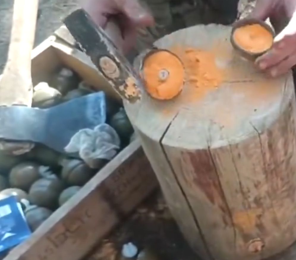 A Russian dismantling RGO and RGN grenades with a hammer.