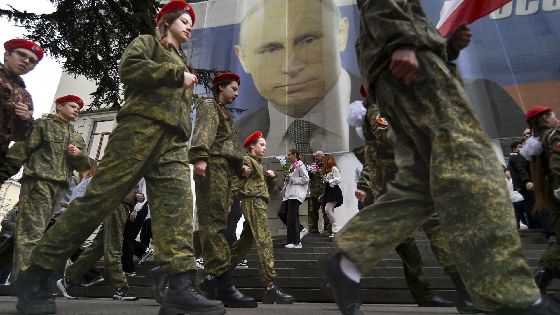 Rosyjska młodzież bierze udział w celebracji 9. rocznicy aneksji Krymu przez Rosję. Na plakacie z podobizną Władimira Putina widnieje napis "Rosja nie zaczyna wojen, Rosja je kończy"