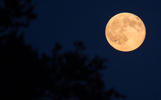 Samolot przelatuje przed Księżycem w pełni w Arlington w Wirginii