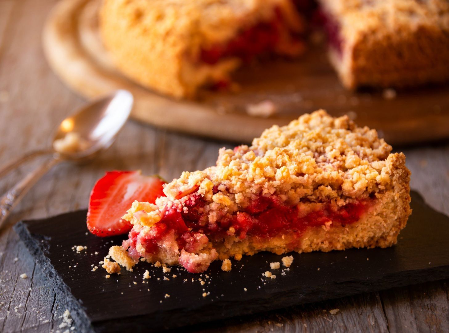 Delicious crumble cake with strawberry on wooden background