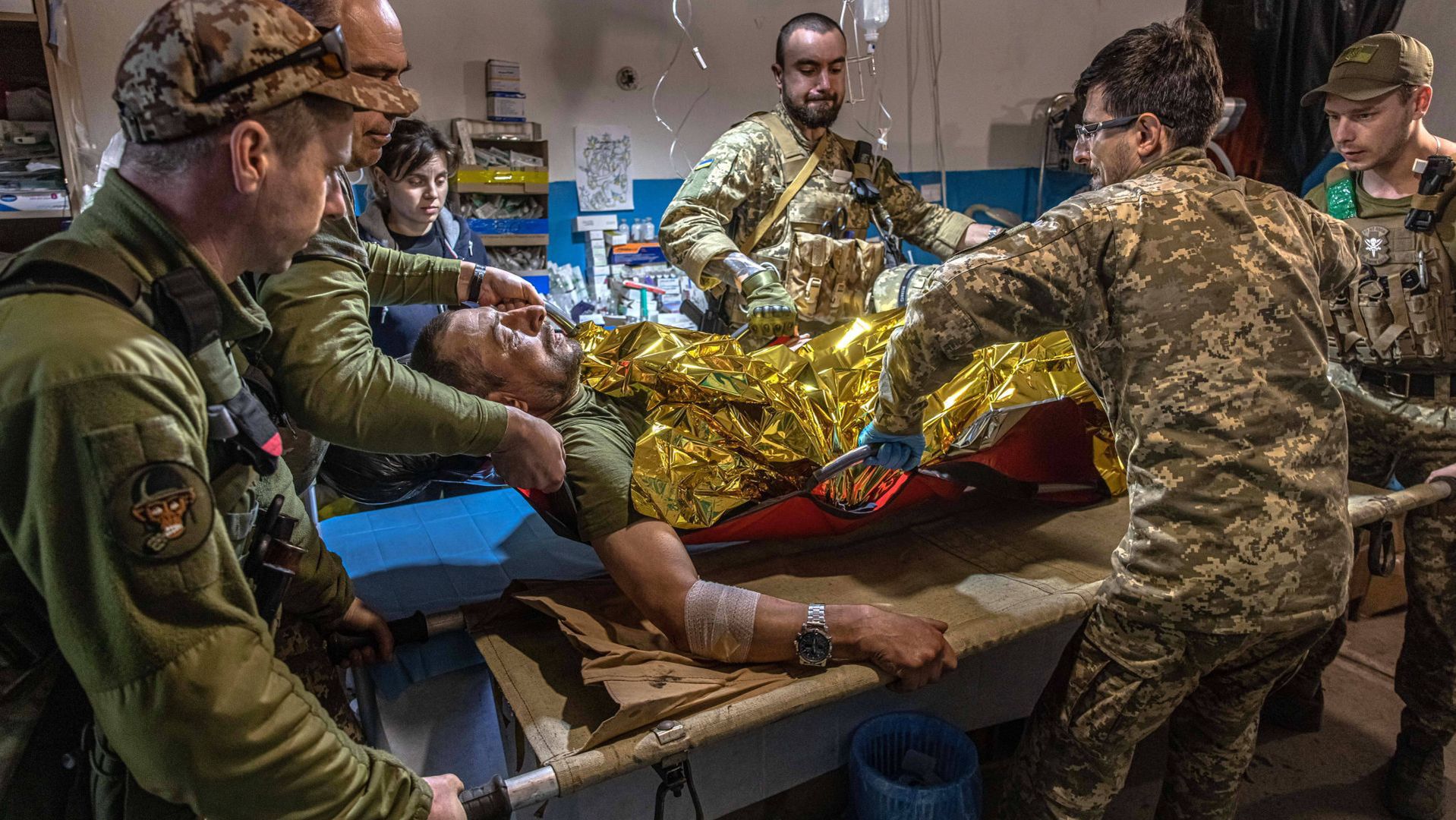 Ukraiński żołnierz ranny podczas walk w okolicach Popasnej. Koledzy przygotowują go do transportu do szpitala