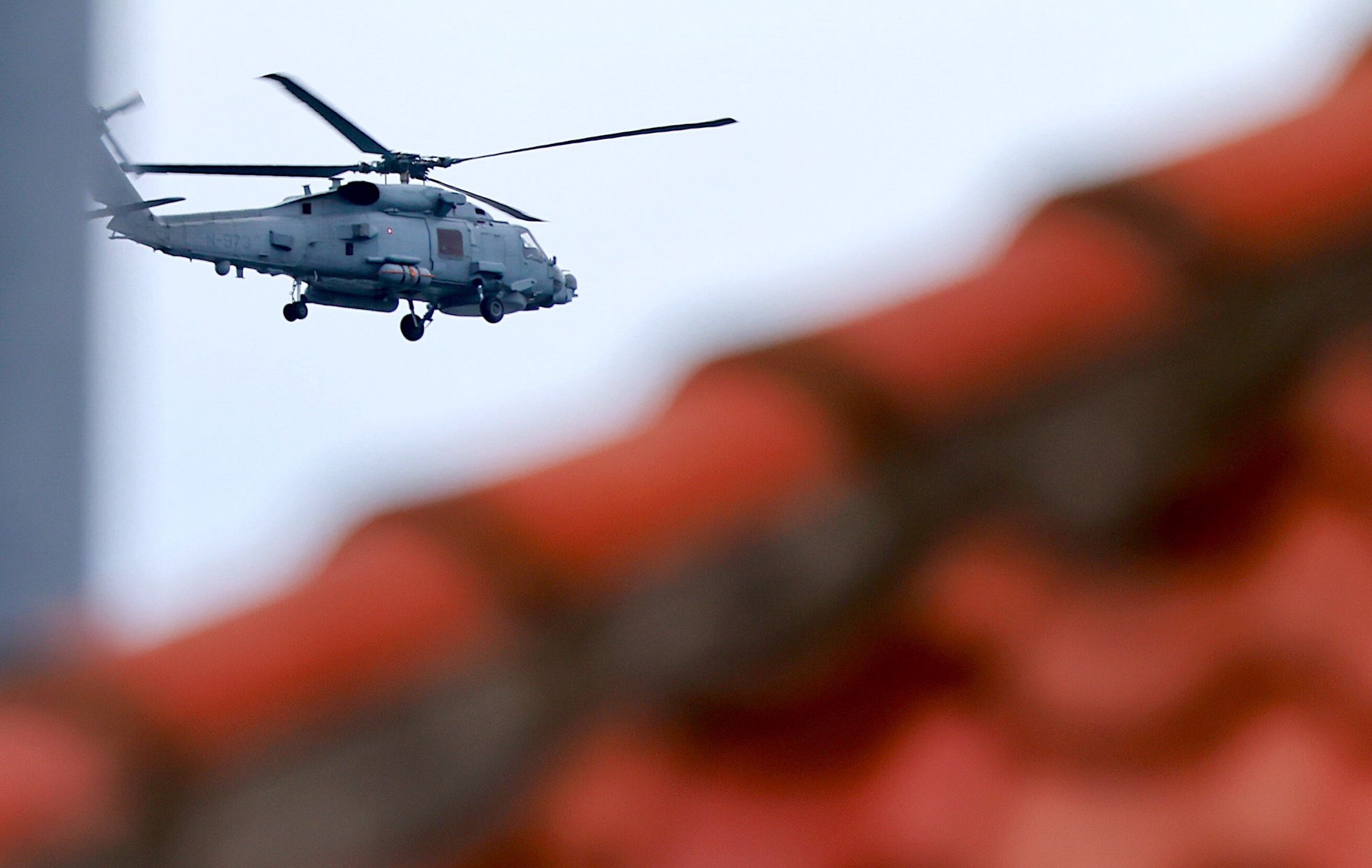 Helikopter wojskowy przelatuje nad miastem Ronne na wyspie Bornholm w Danii