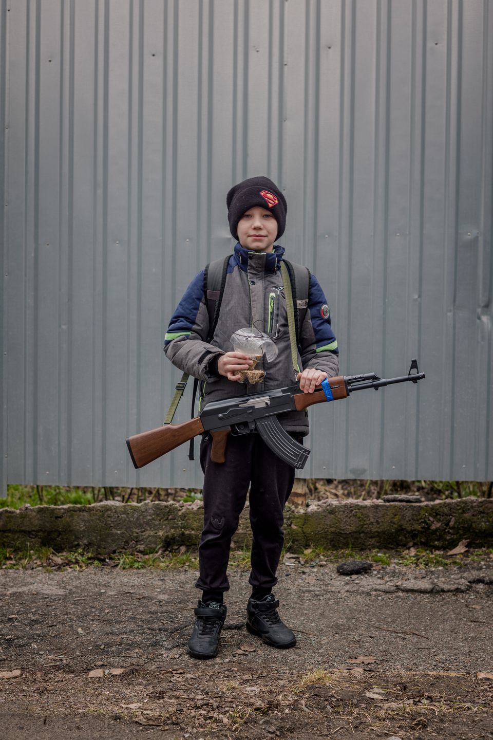 Nikopol. 10-letni Sasza z zabawkowym Kałasznikowem. Chłopiec idzie się bawić z rówieśnikami. 