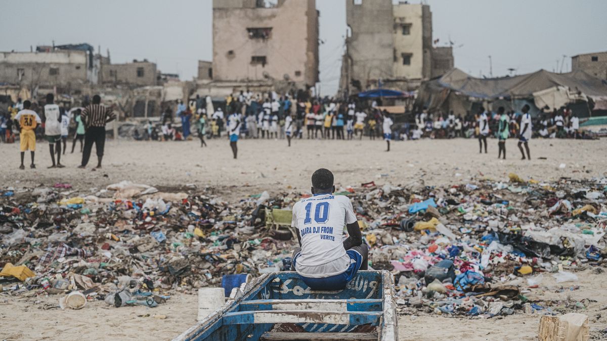 GUET NDAR, SENEGAL - AUGUST 13: Young people who want to escape to Europe spend most of their time playing soccer on a dirt field as the port is one of the points of departure where young Africans try to cross illegally to Europe in the hope of a better life in Saint-Louis, Senegal on August 13, 2024. In Guet Ndar, where almost all inhabitants are fishermen, crowded and narrow streets lead to a long sandy beach lined with hundreds of colorful fishing boats. Young people, unemployed due to the development of industrial fishing, find the solution by smuggling to Europe via the Canary Islands. (Photo by Francisco De Borja Abargues Carbo/Anadolu via Getty Images)